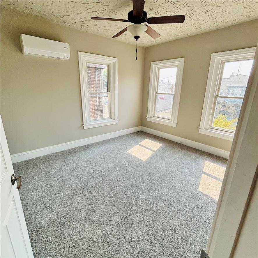 718 Linden Street Bethlehem, PA 18018 - Photo 2 of 19 A comfortable bedroom with ample natural light and a practical ceiling fan, perfect for relaxation.