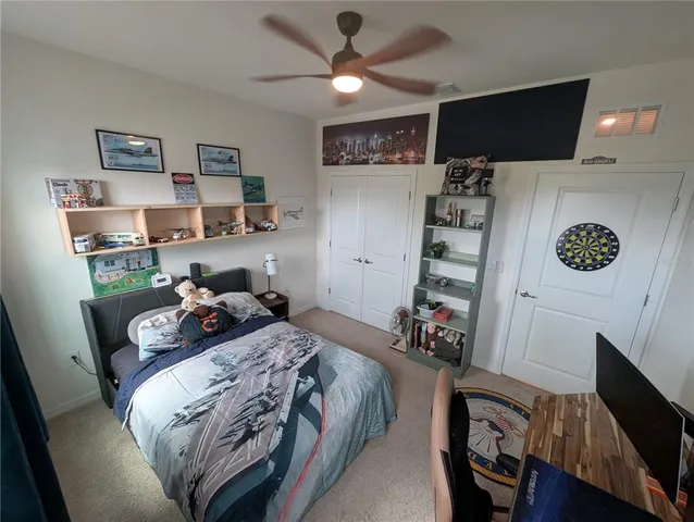 a bed room with a bed tv and a chair