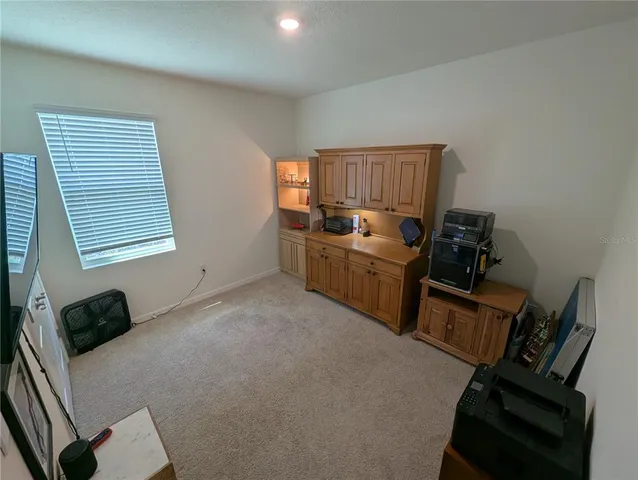 a room with a wall painting and a lamp on table