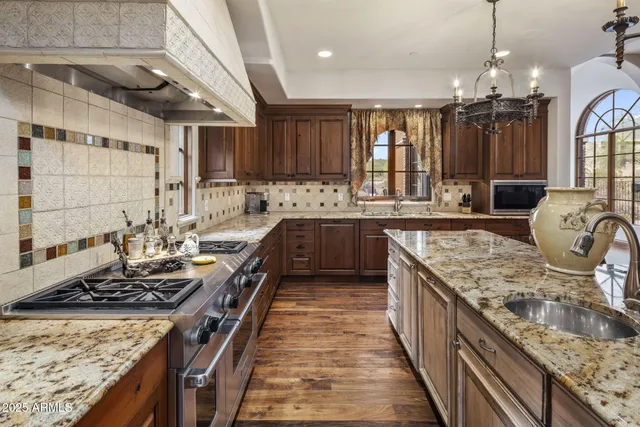 a view of living room kitchen with granite countertop stainless steel appliances and wooden floor