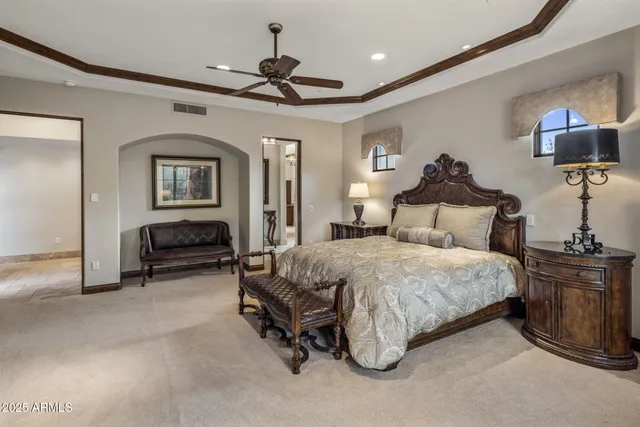 a bedroom with a bed a window and flat screen tv