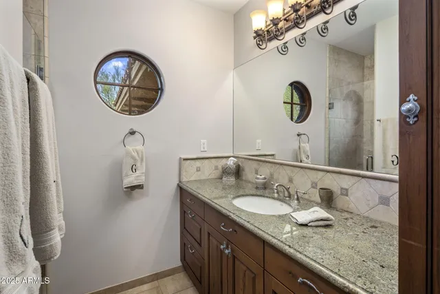 a bathroom with a granite countertop toilet sink and mirror