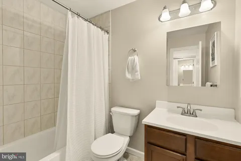 a bathroom with a sink vanity mirror and toilet