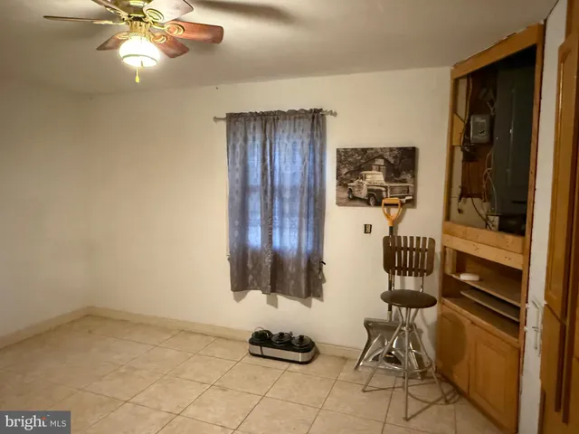 a room with chandelier fan and windows