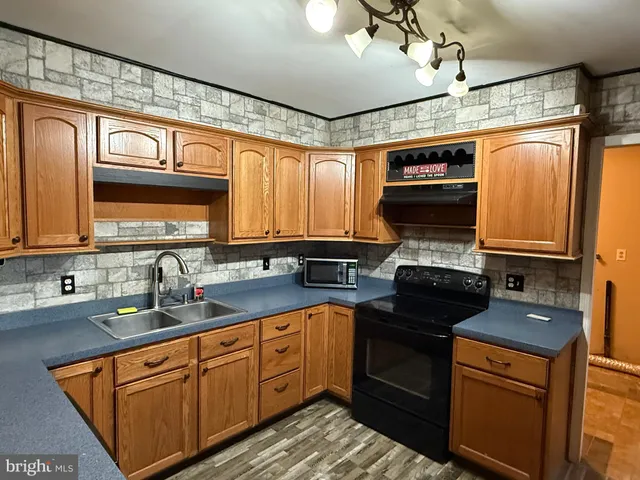 a kitchen with stainless steel appliances a sink cabinets and a window