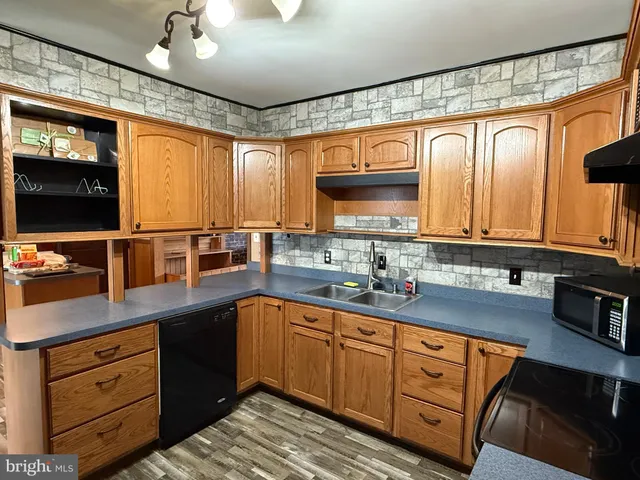 a kitchen with stainless steel appliances granite countertop a sink and cabinets