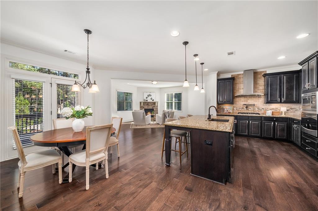 6660 Tulip Plantation Road Alpharetta, GA 30004 - Photo 12 of 68 a view of a dining room and livingroom with furniture wooden floor a chandelier