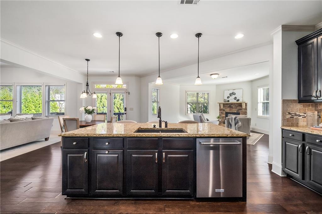 6660 Tulip Plantation Road Alpharetta, GA 30004 - Photo 15 of 68 a kitchen with stainless steel appliances granite countertop a sink a stove and a wooden floor