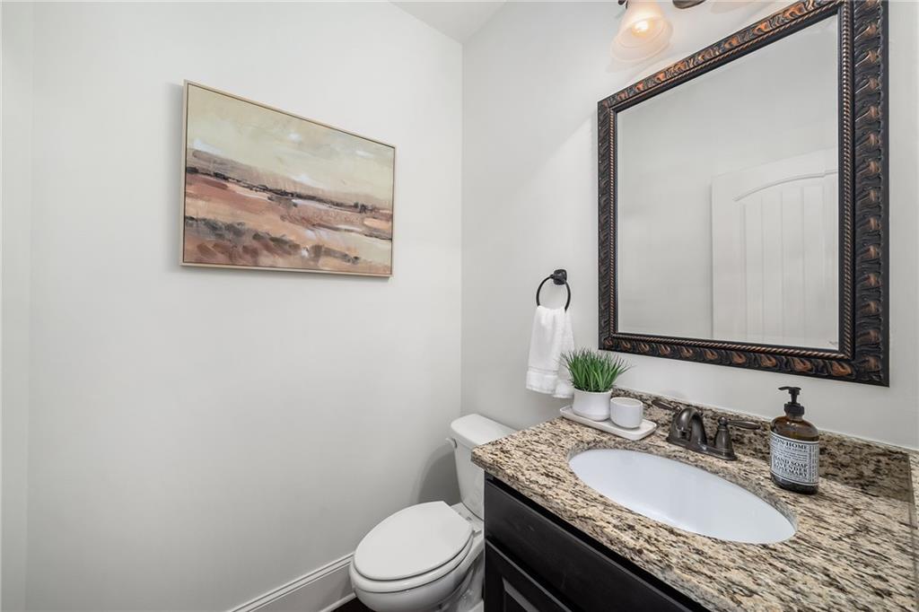 6660 Tulip Plantation Road Alpharetta, GA 30004 - Photo 21 of 68 a bathroom with a granite countertop toilet a sink and a mirror