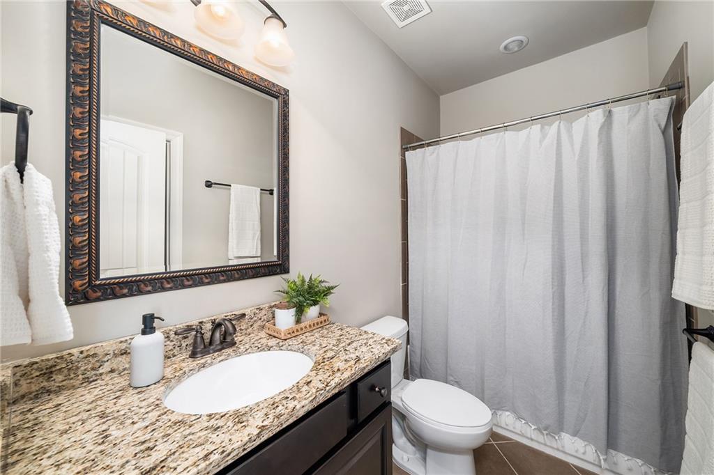 6660 Tulip Plantation Road Alpharetta, GA 30004 - Photo 24 of 68 a bathroom with a granite countertop sink and a mirror