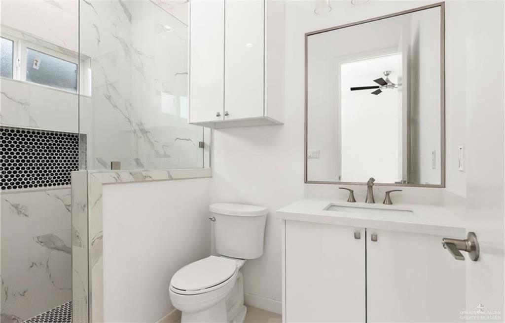 1912 East Ridgeway Circle Edinburg, TX 78542 - Photo 7 of 10 a bathroom with a granite countertop sink a toilet and a mirror