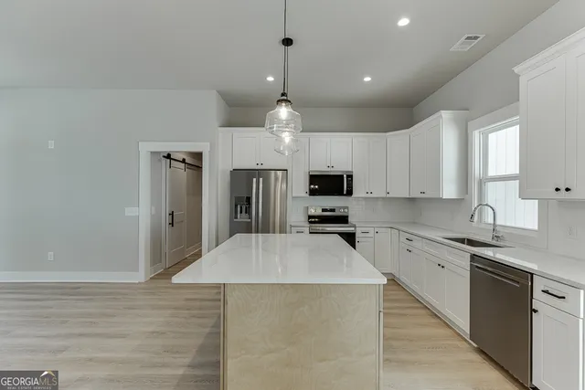 a kitchen with kitchen island a counter top a stove and cabinets