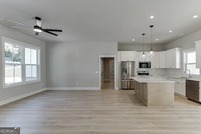 an empty room with a window and a fan
