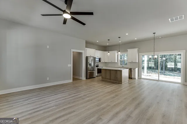 a view of empty room with wooden floor and window