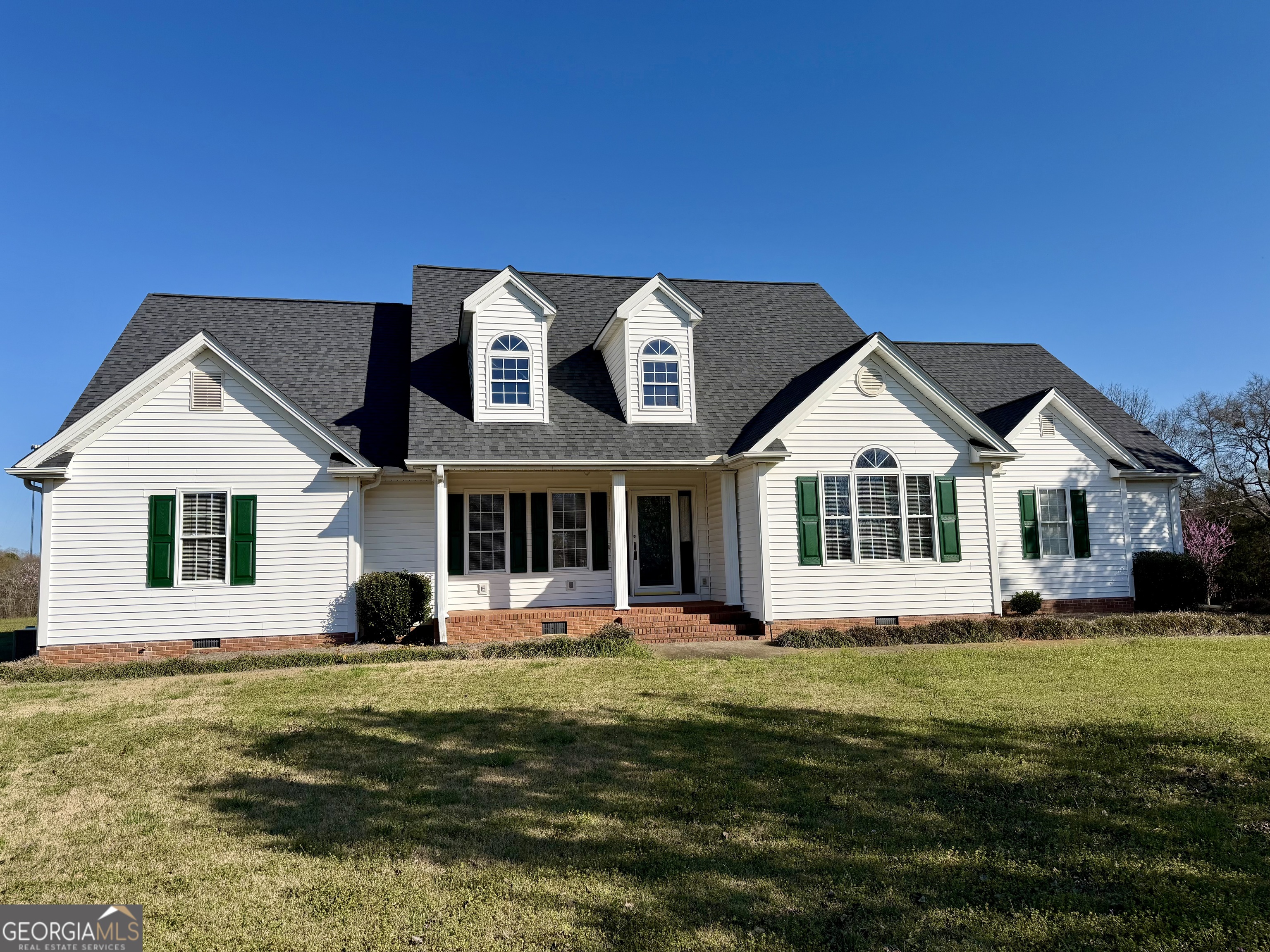 494 Broad Street Bowman, GA 30624 - Photo 4 of 65 a front view of a house with a garden and trees