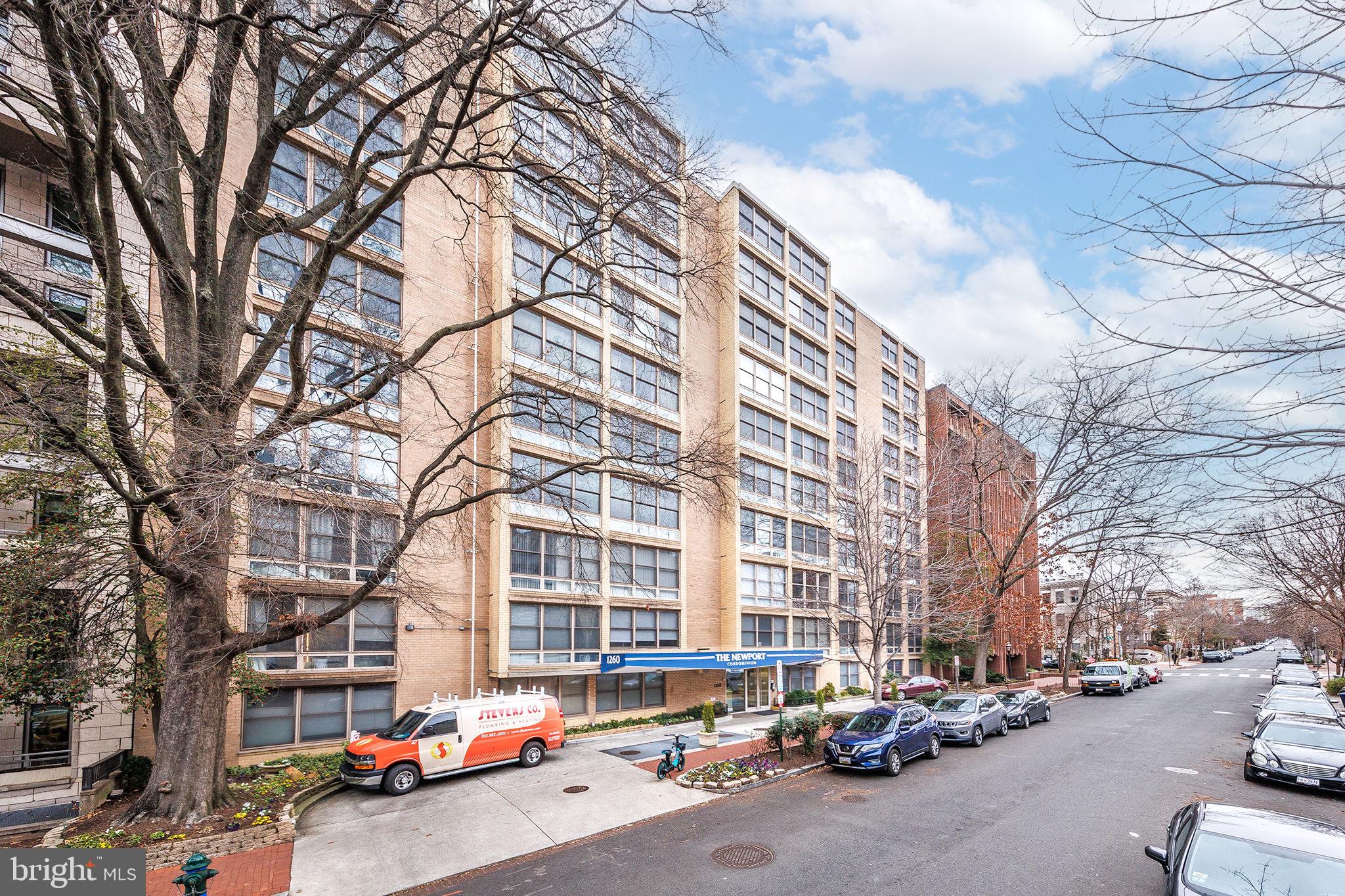 a city street lined with parked cars and buildings
