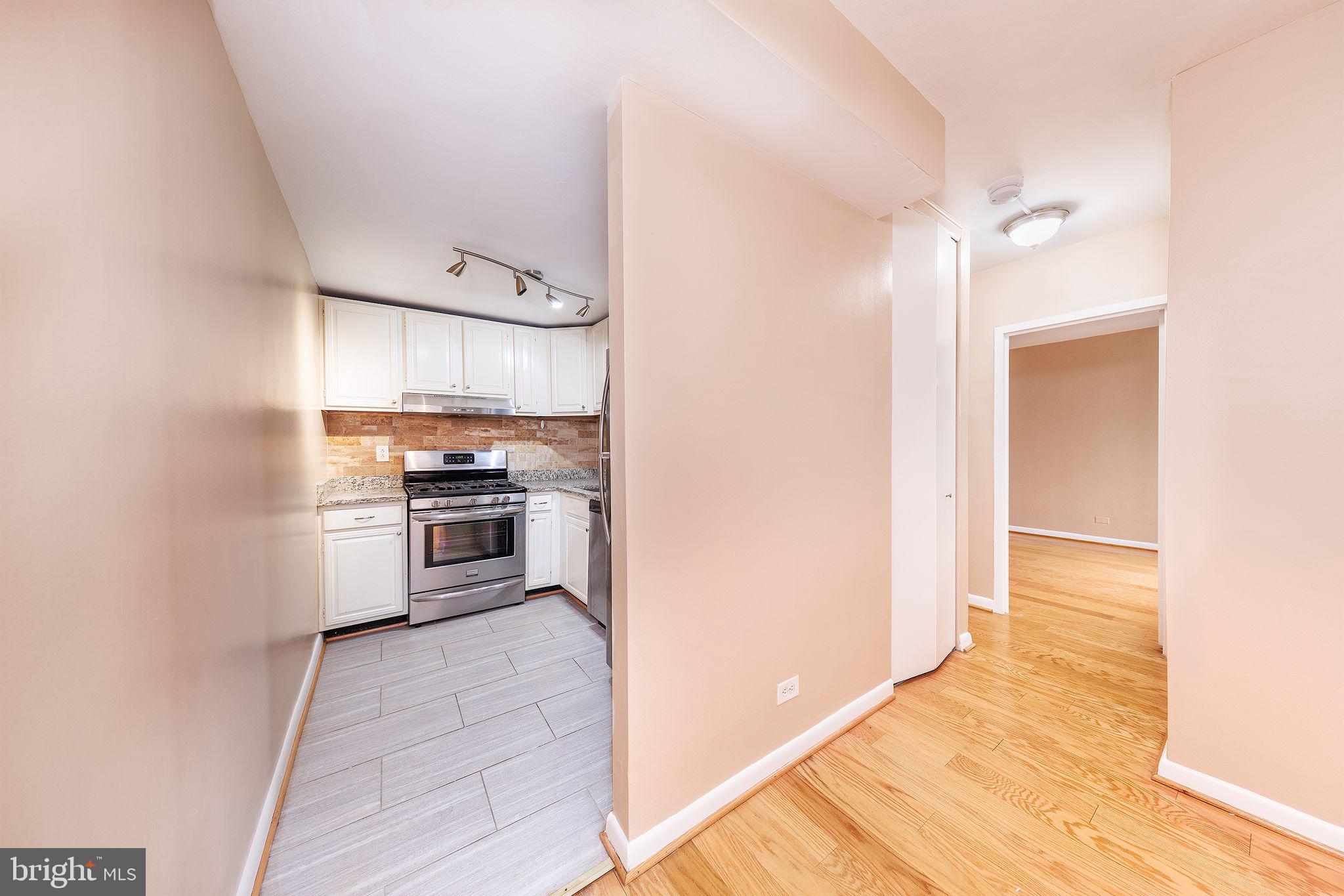 1260 21st Street Northwest, Unit 1004 Washington, DC 20036 - Photo 11 of 27 a kitchen with a refrigerator and a stove top oven