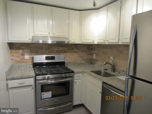 a kitchen with granite countertop cabinets stainless steel appliances and a sink
