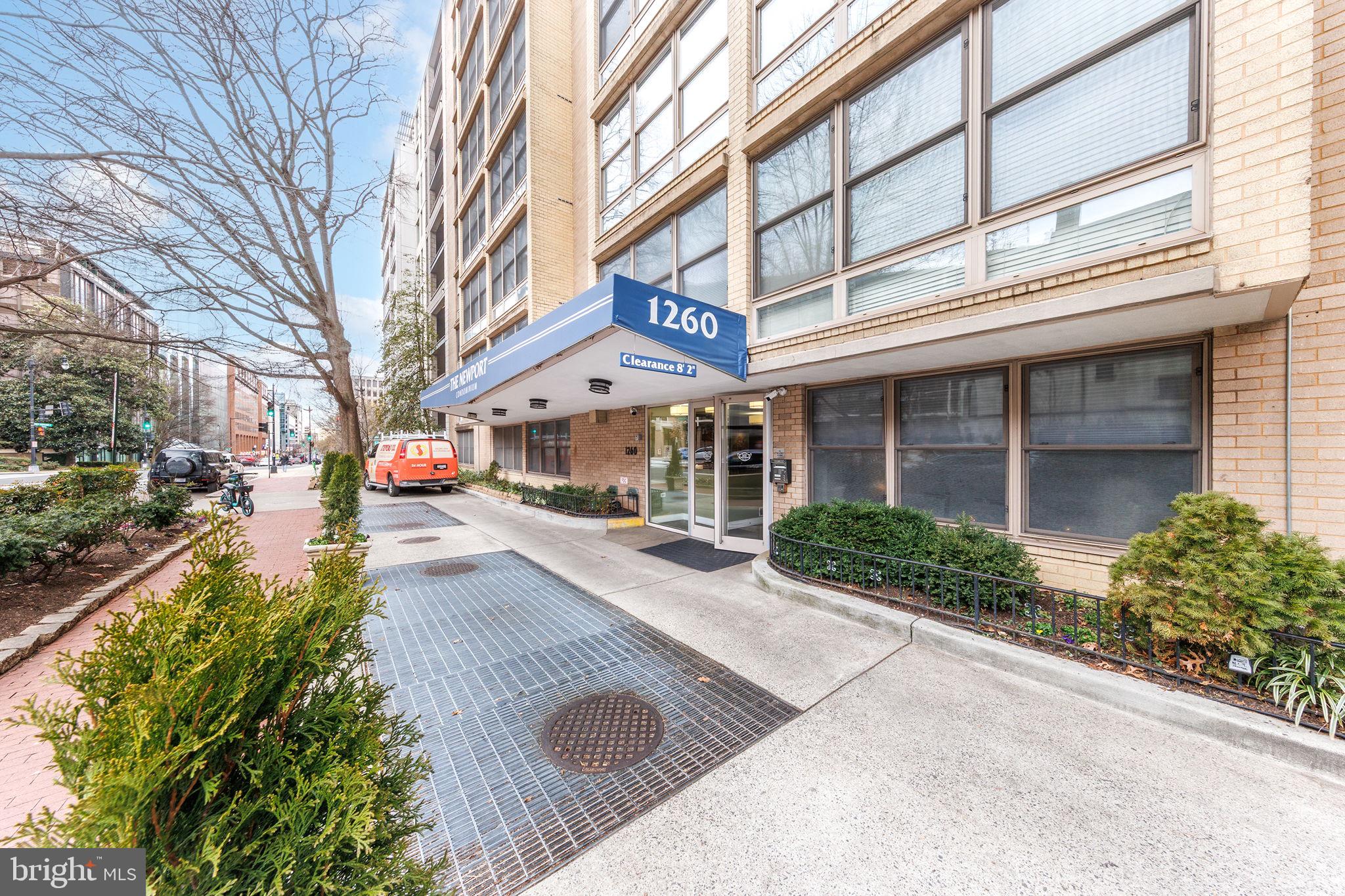 1260 21st Street Northwest, Unit 1004 Washington, DC 20036 - Photo 2 of 27 a front view of a building with trees and retail shops