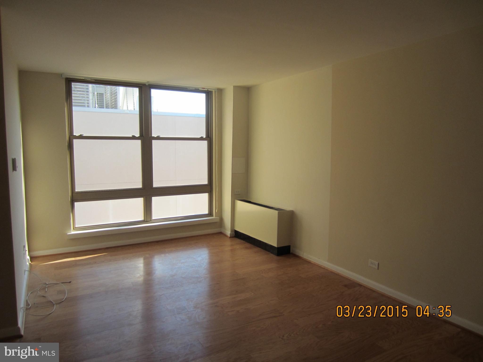 1260 21st Street Northwest, Unit 1004 Washington, DC 20036 - Photo 4 of 8 a view of a livingroom with wooden floor and a window