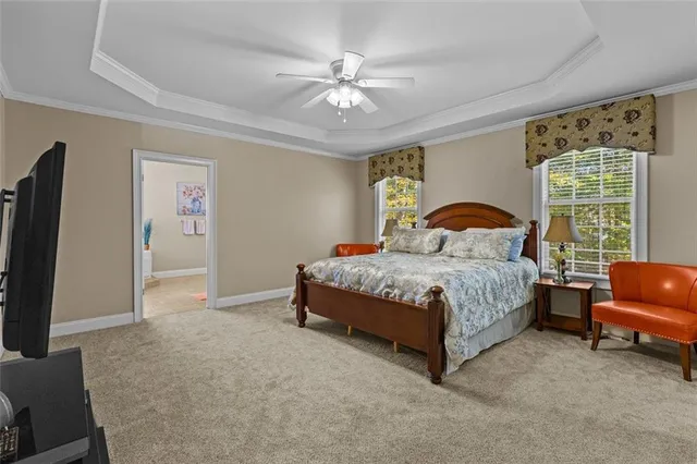 a spacious bedroom with a bed and a flat screen tv on dresser