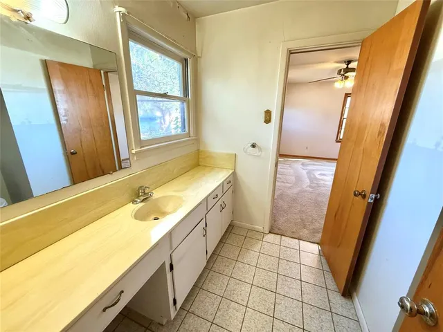 a spacious bathroom with a tub sink and mirror