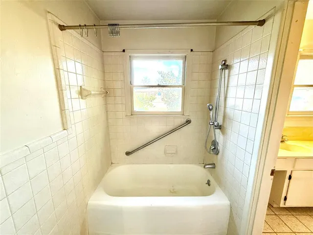 a bathroom with a shower and a bath tub