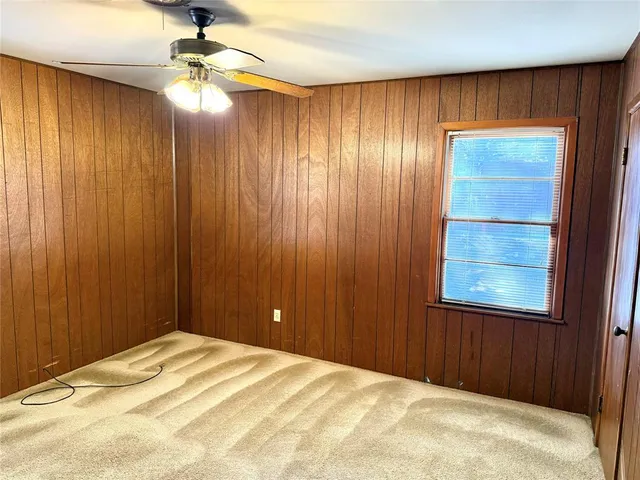 a bedroom with a bed and a chandelier fan
