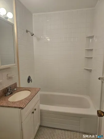 a bathroom with a granite countertop sink a toilet and shower