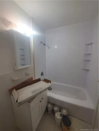 a bathroom with a granite countertop sink a toilet and bathtub
