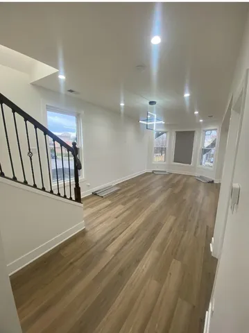 a view of an empty room with wooden floor