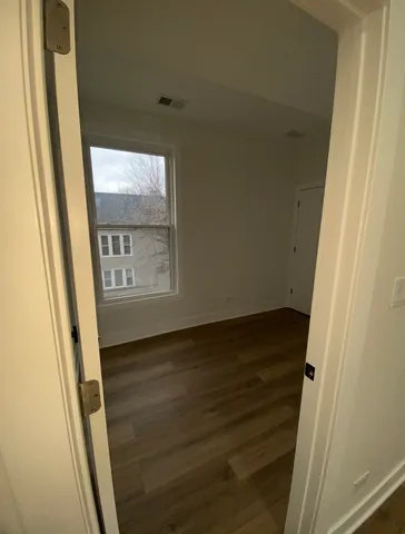 a view of a hallway with wooden floor