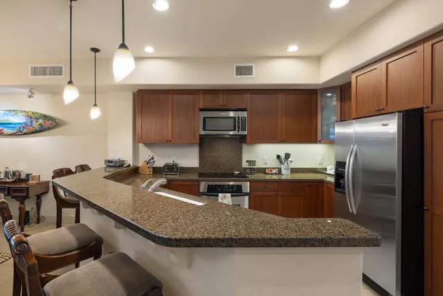a kitchen with stainless steel appliances granite countertop a sink a stove and a refrigerator