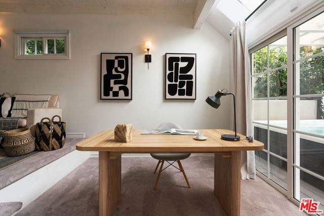 a view of a workspace with furniture and a window