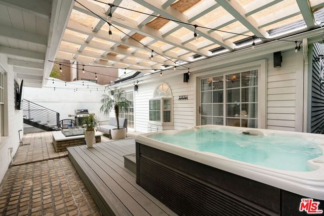 a living room with stainless steel appliances furniture and a flat screen tv