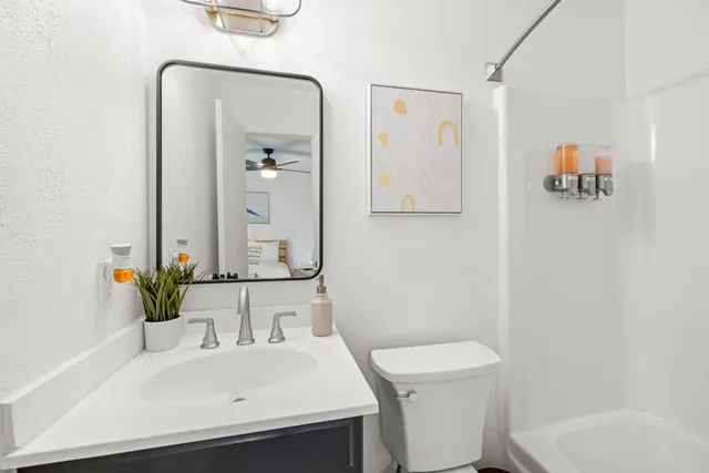 a bathroom with a sink a toilet and shower