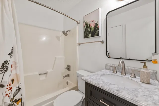 a bathroom with a granite countertop sink toilet and shower