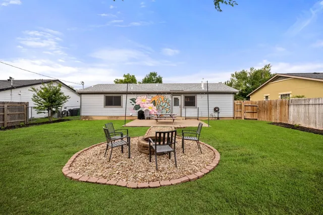a view of a house with backyard sitting area and garden