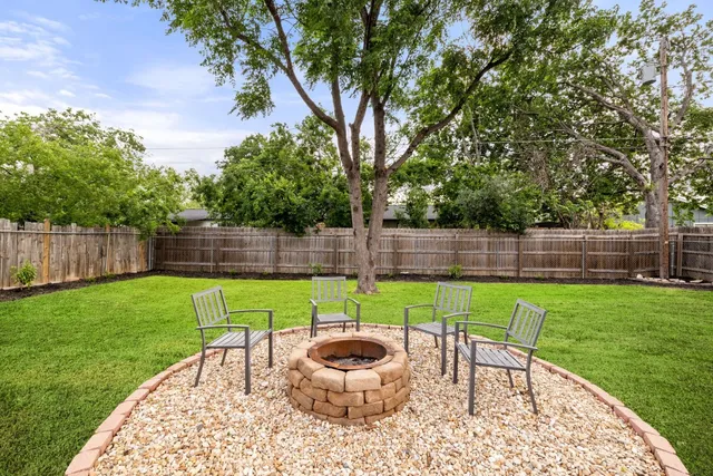 a view of a backyard with furniture and a garden