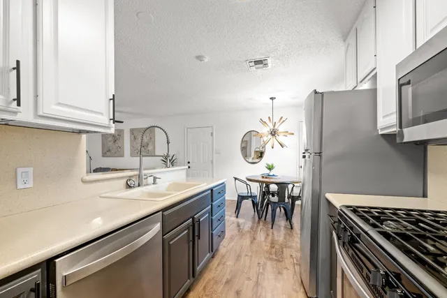 a kitchen with a sink a stove and chairs