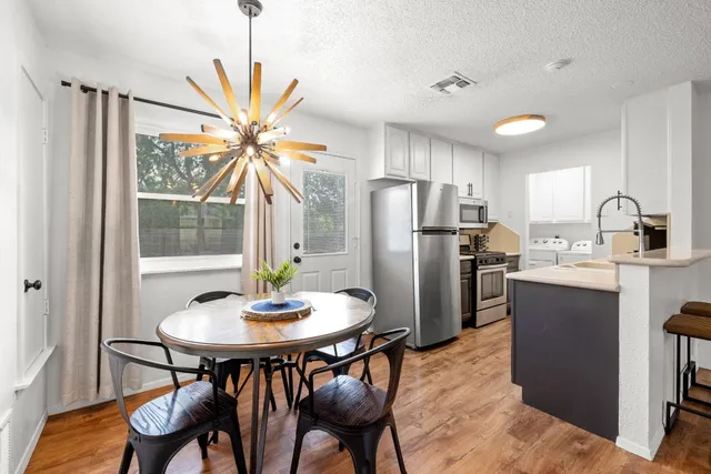 a kitchen with stainless steel appliances a dining table and chairs