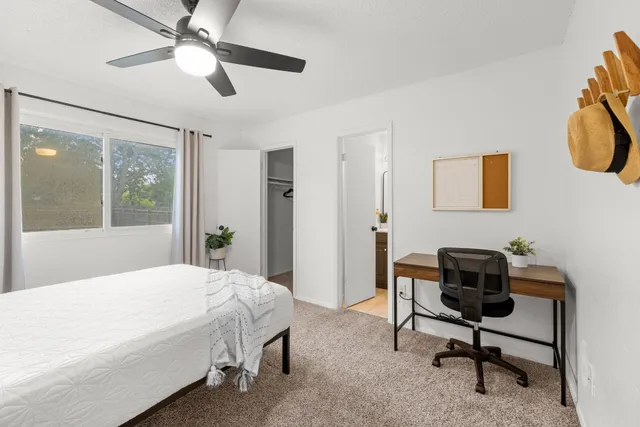 a bedroom with a bed a desk and chair