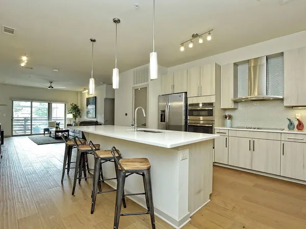 a kitchen with a sink a counter space appliances and cabinets