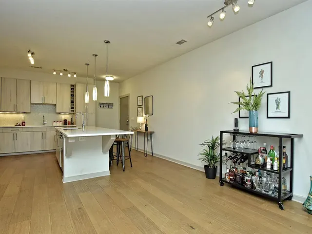 a kitchen with a sink a center island a counter space and stainless steel appliances