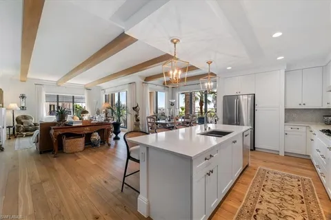 a large white kitchen with a table and chairs