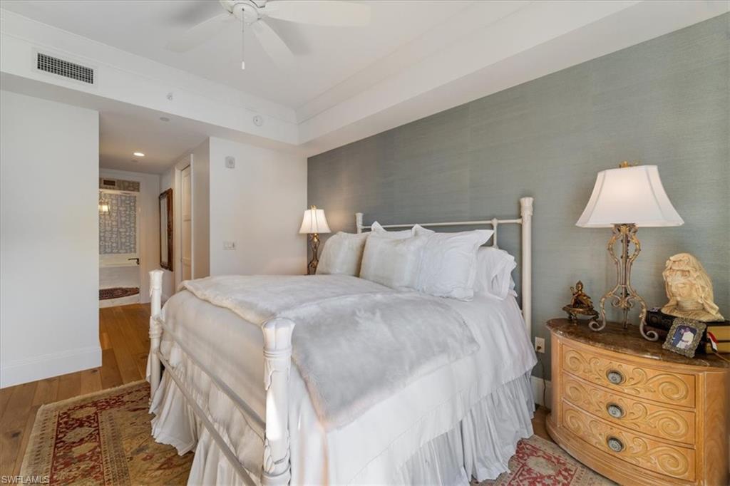 1135 3rd Avenue South, Unit 409 Naples, FL 34102 - Photo 20 of 44 a bedroom with a bed and a lamp on dresser