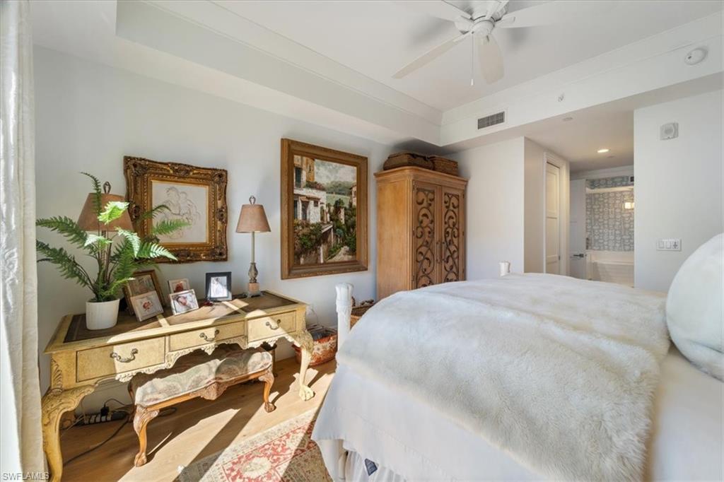 1135 3rd Avenue South, Unit 409 Naples, FL 34102 - Photo 21 of 44 a bedroom with a bed table and dresser