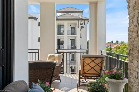 a view of a balcony with chair and potted plants
