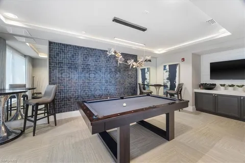 a room with furniture pool table and flat screen tv