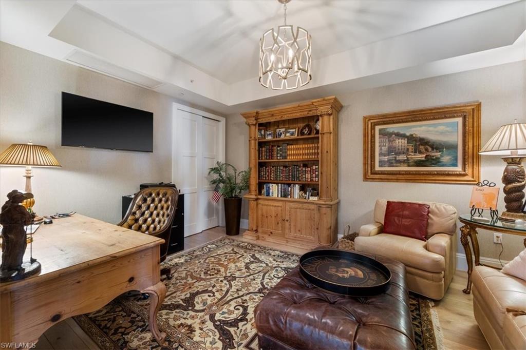 1135 3rd Avenue South, Unit 409 Naples, FL 34102 - Photo 4 of 44 a bedroom with furniture and a chandelier